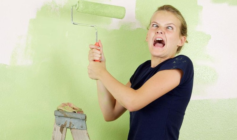 woman looking angry while coloring a wall