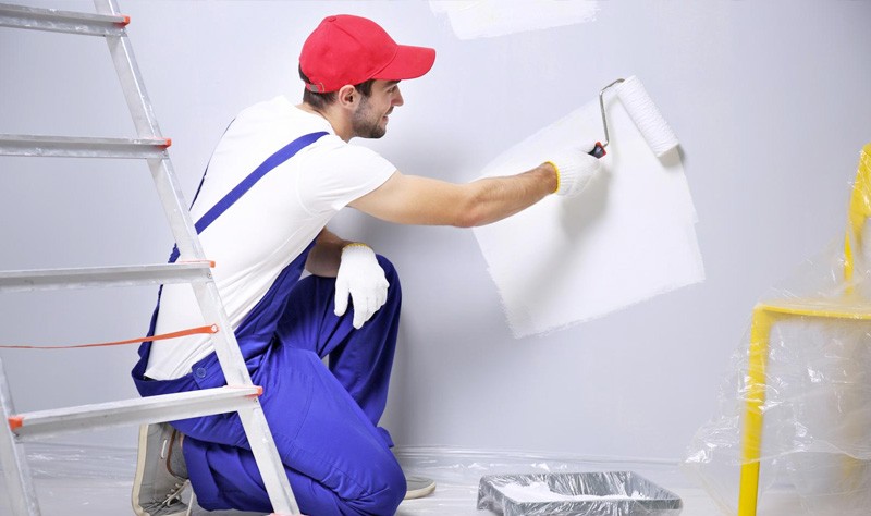 young professional painting a wall