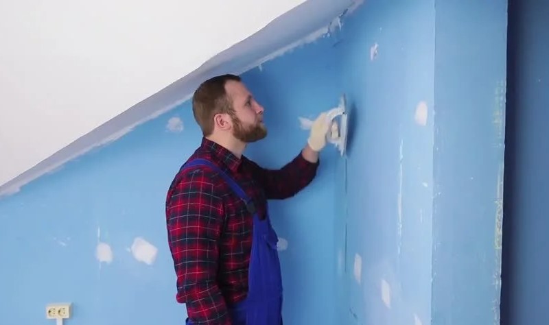 young man coloring a wall