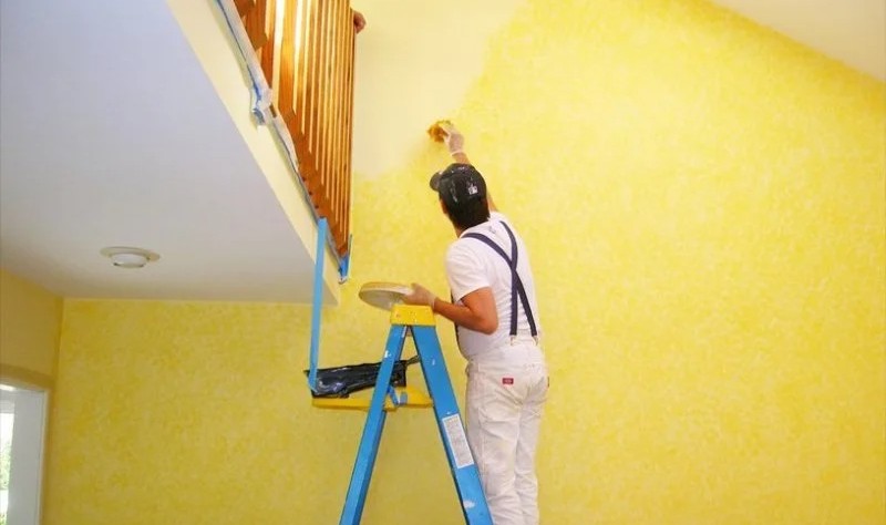 young man coloring a wall