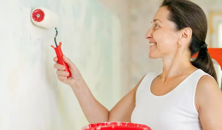 woman painting a wall following DIY methods